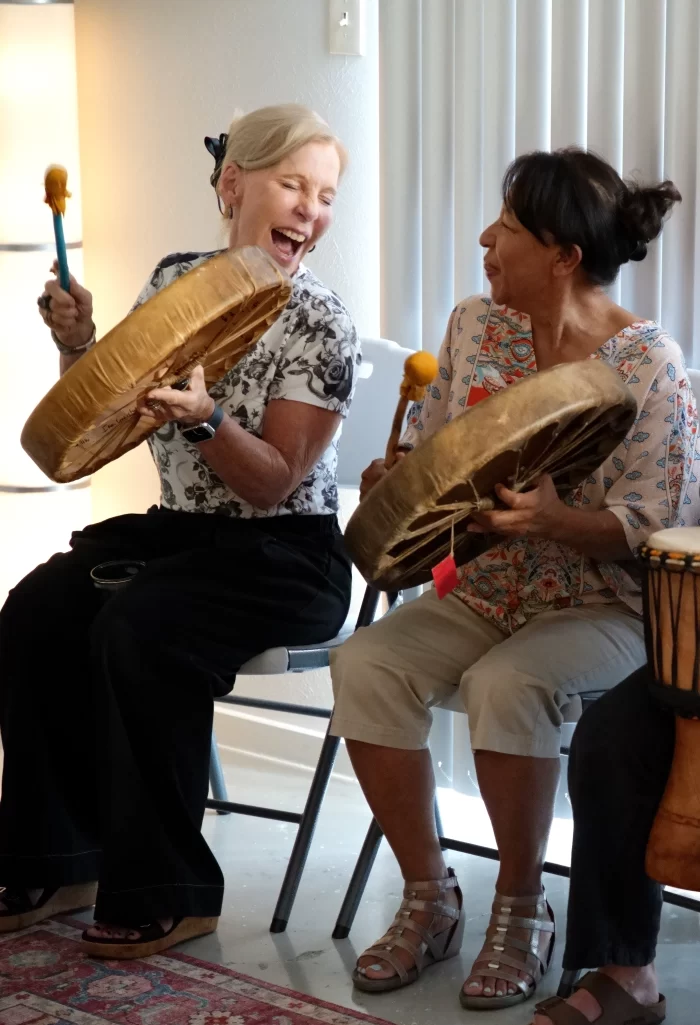 Close-up of hands using vibrant paints and mixed media during an intuitive art session at Shakti Creative Wellness Center.