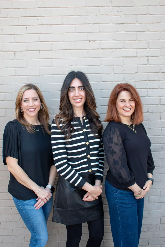 Dr. Candice Hutcheson hugging a happy young patient in the colorful hallway of her Richardson pediatric dental office.