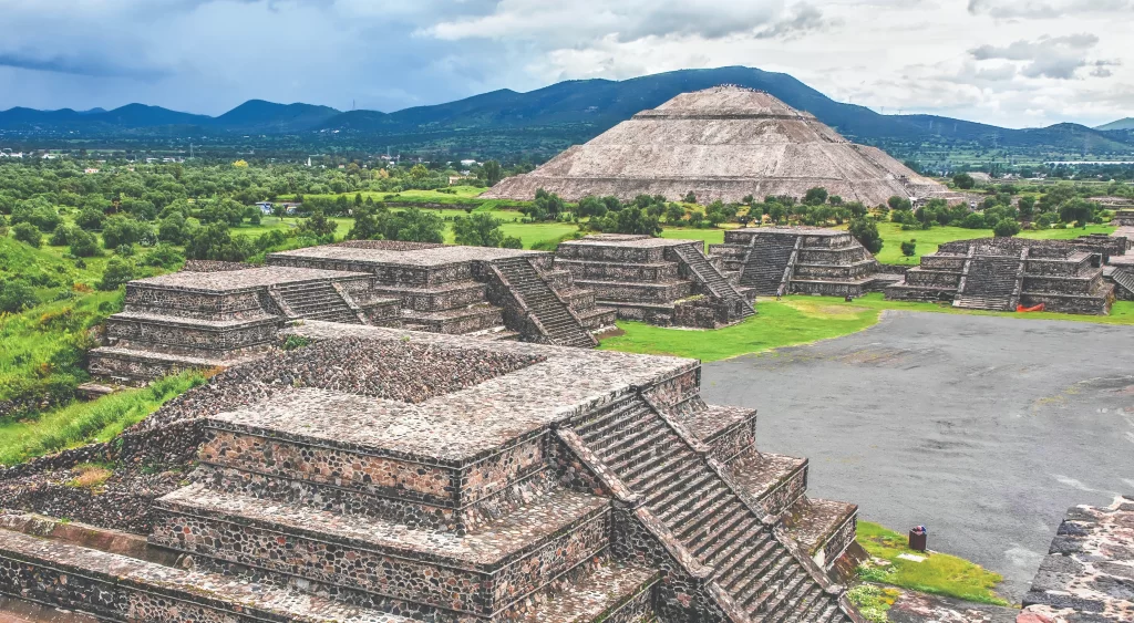 The massive Sun Pyramid at Teotihuacan under a bright sky, showing the impressive stone architecture of the ancient Aztec civilization.
